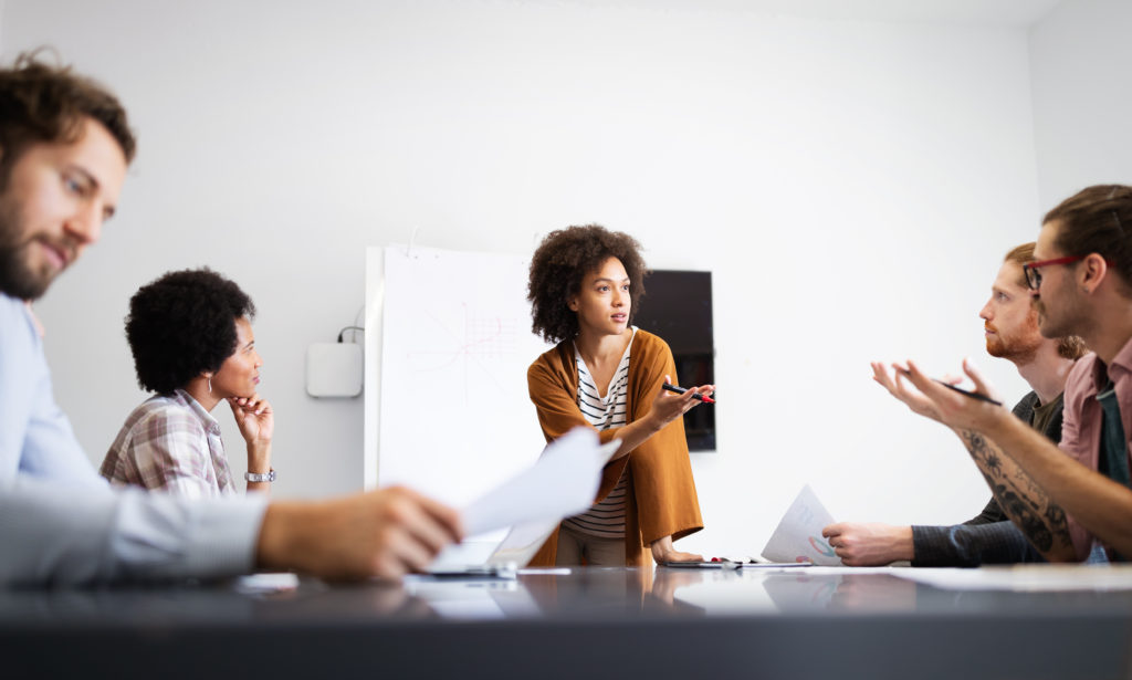 Female addressing conference room with attendees
